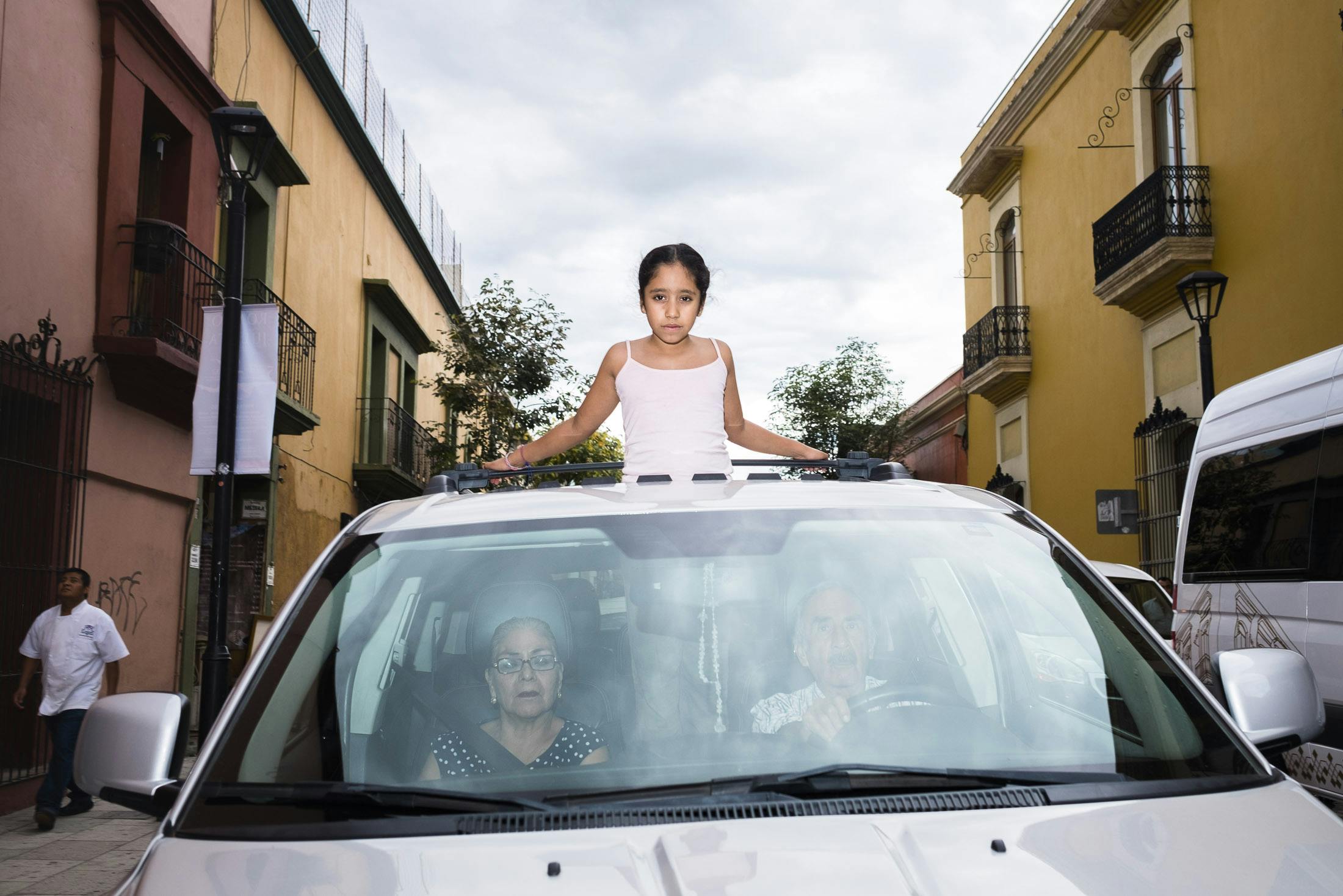 Girl standing out of sun roof whilst driving in Mexico