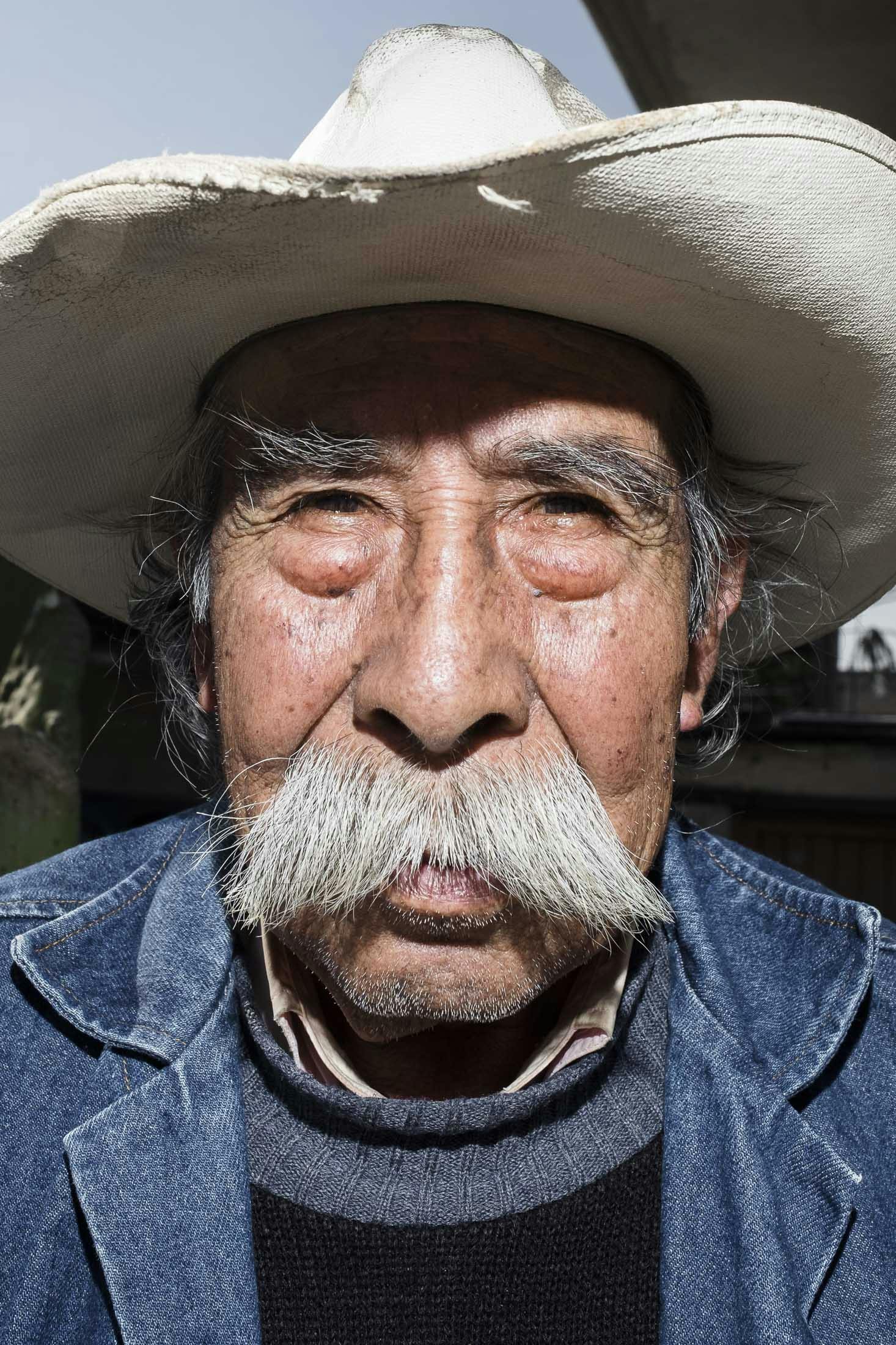 Old man in Mexico wearing cowboy had and moustache 