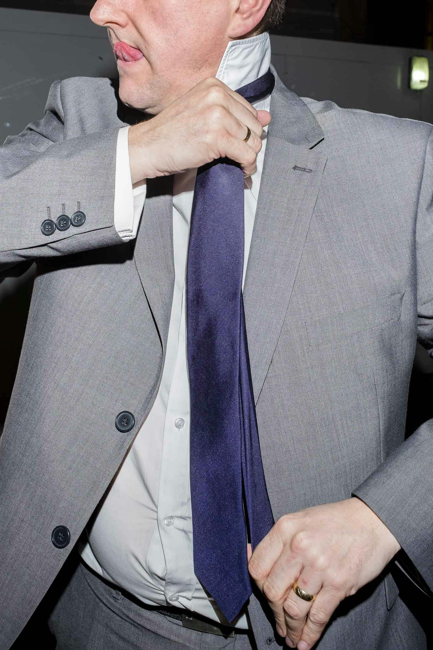 Business man adjusting tie and licking lips