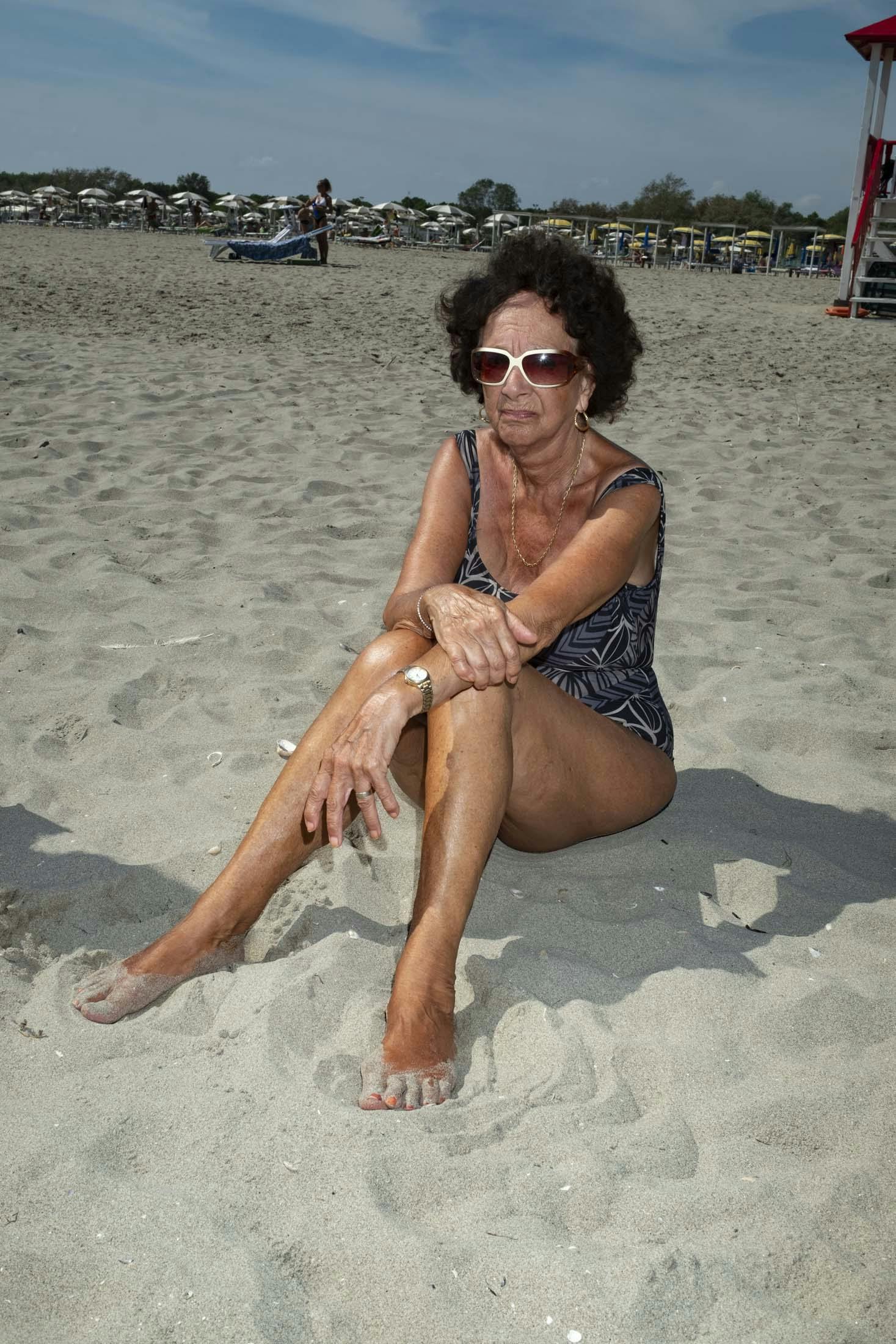 woman sitting on beach with metallic sun glasses 