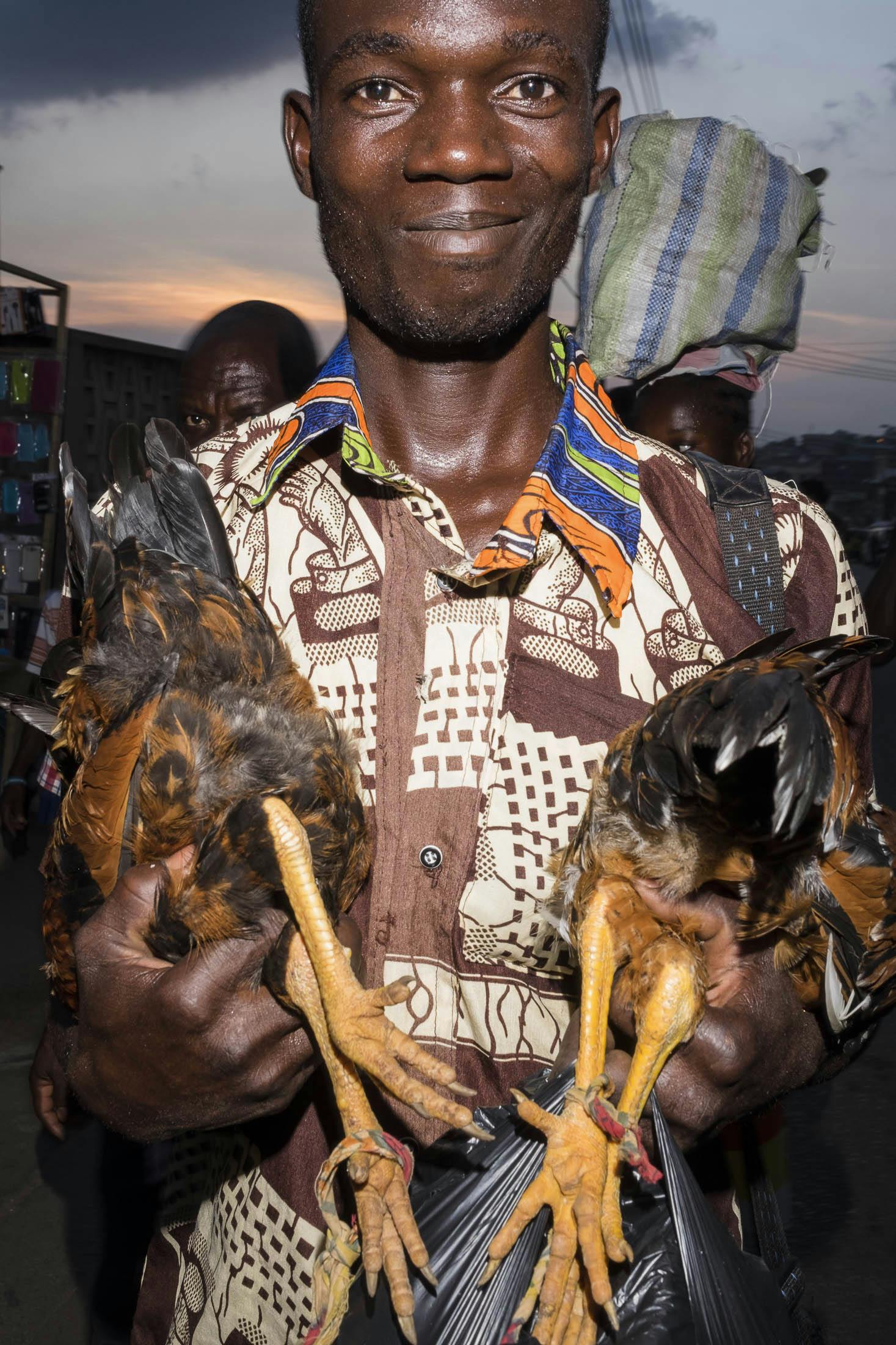 Man holding two chickens in Ghana
