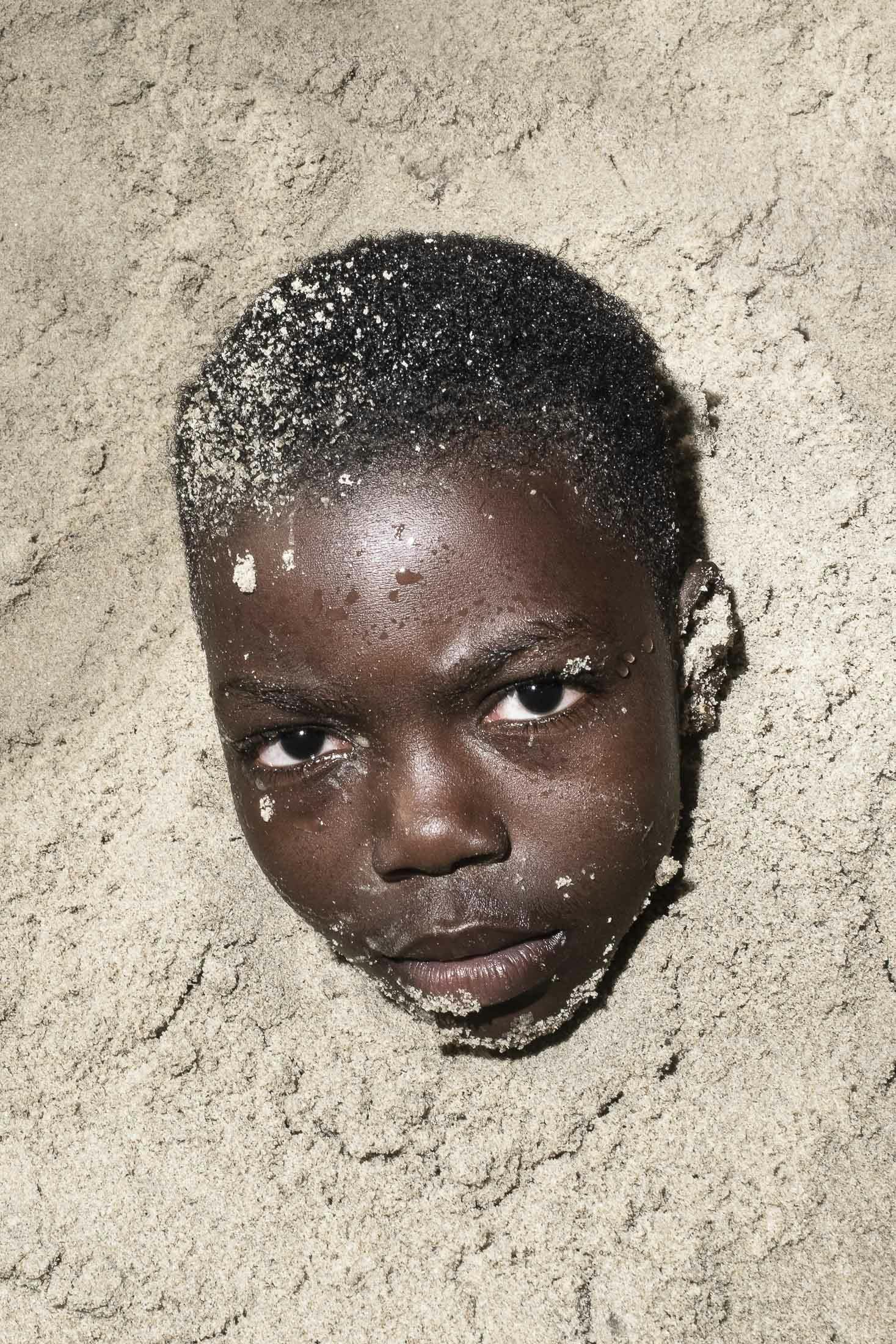 Boy buried in Sand in Accra, Ghana
