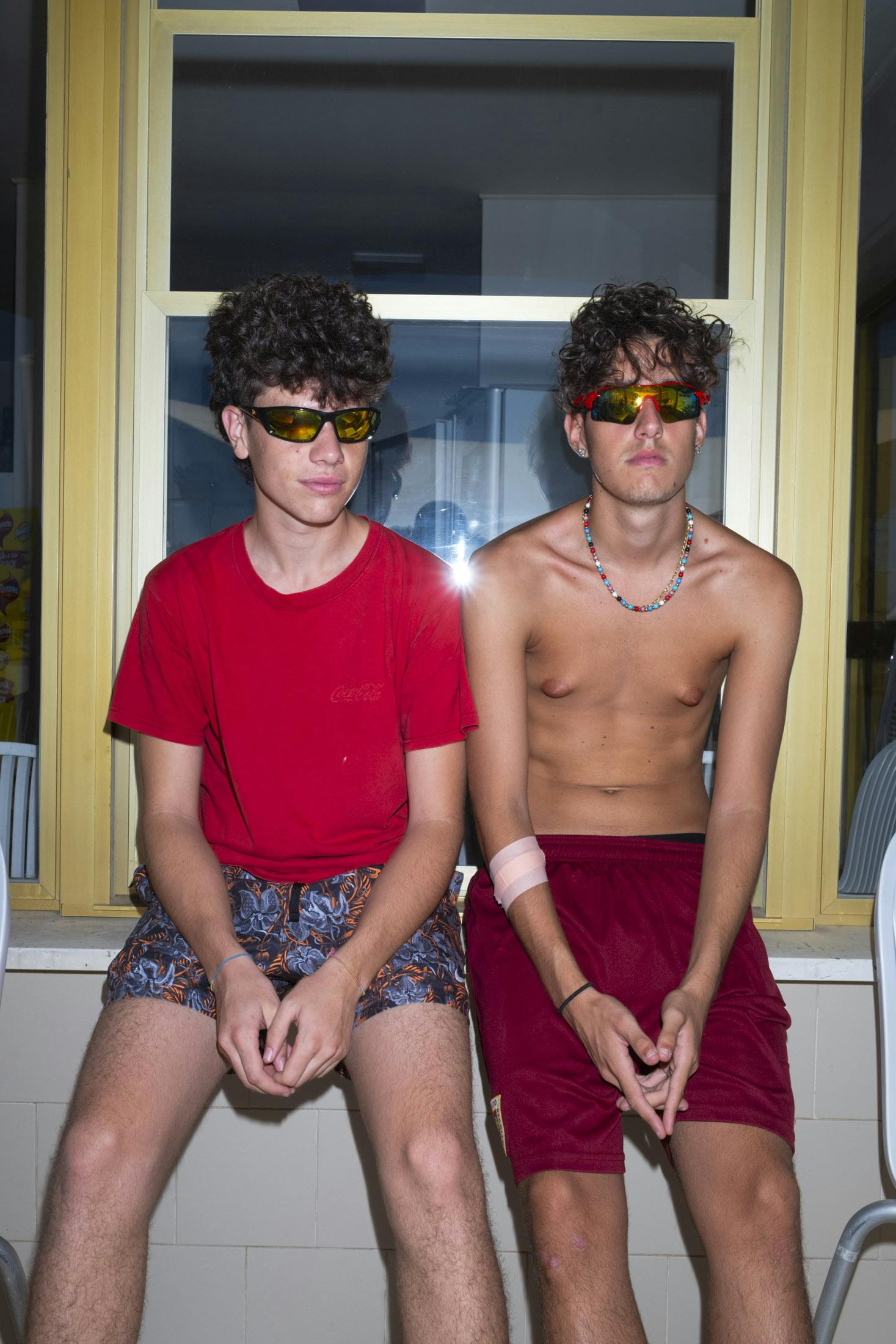 two boys wearing sun glasses on the beach